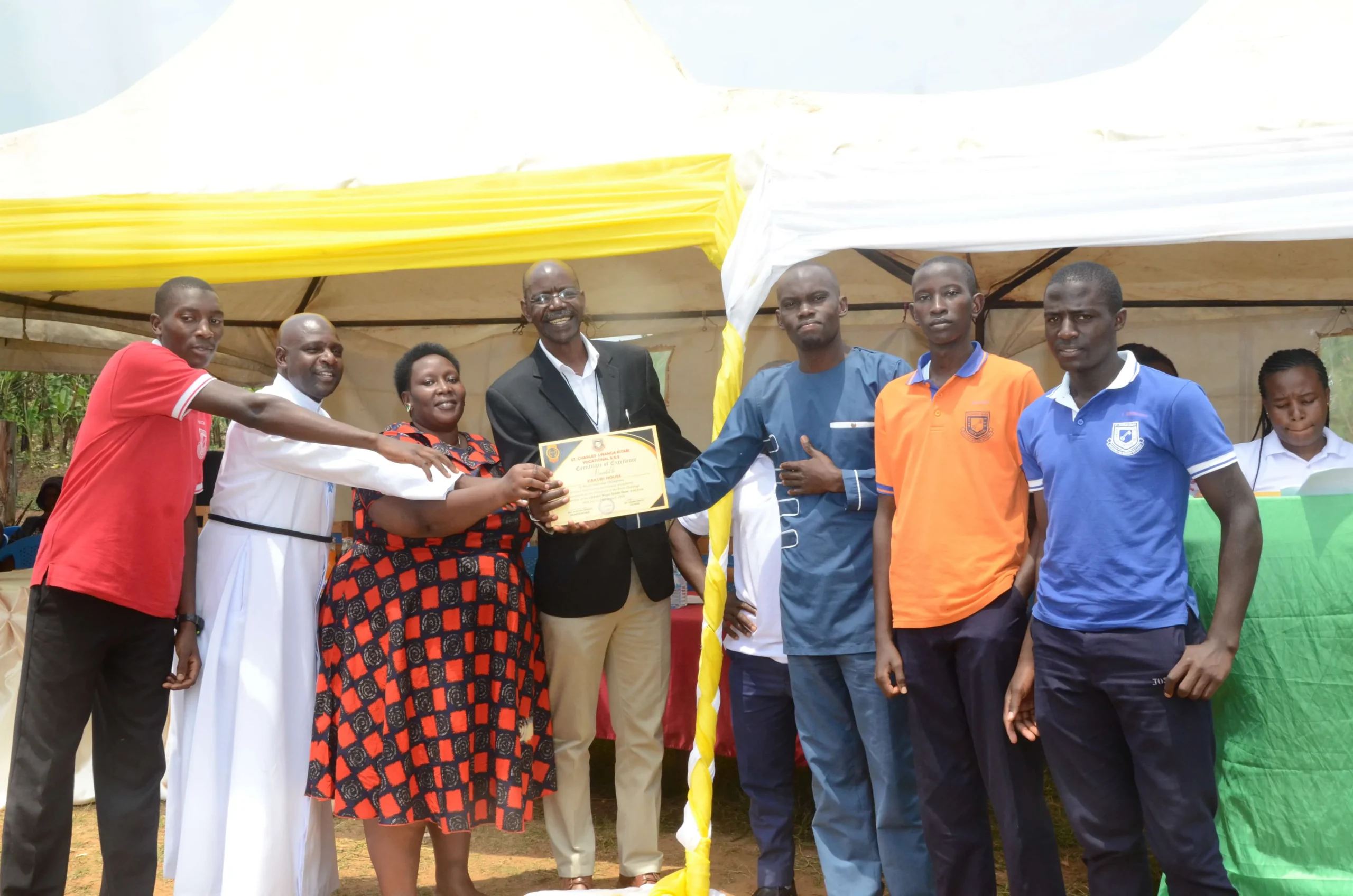 Overall champions receiving award with Headteacher Br. Gordian Twesigye at Chavoc Talent Show